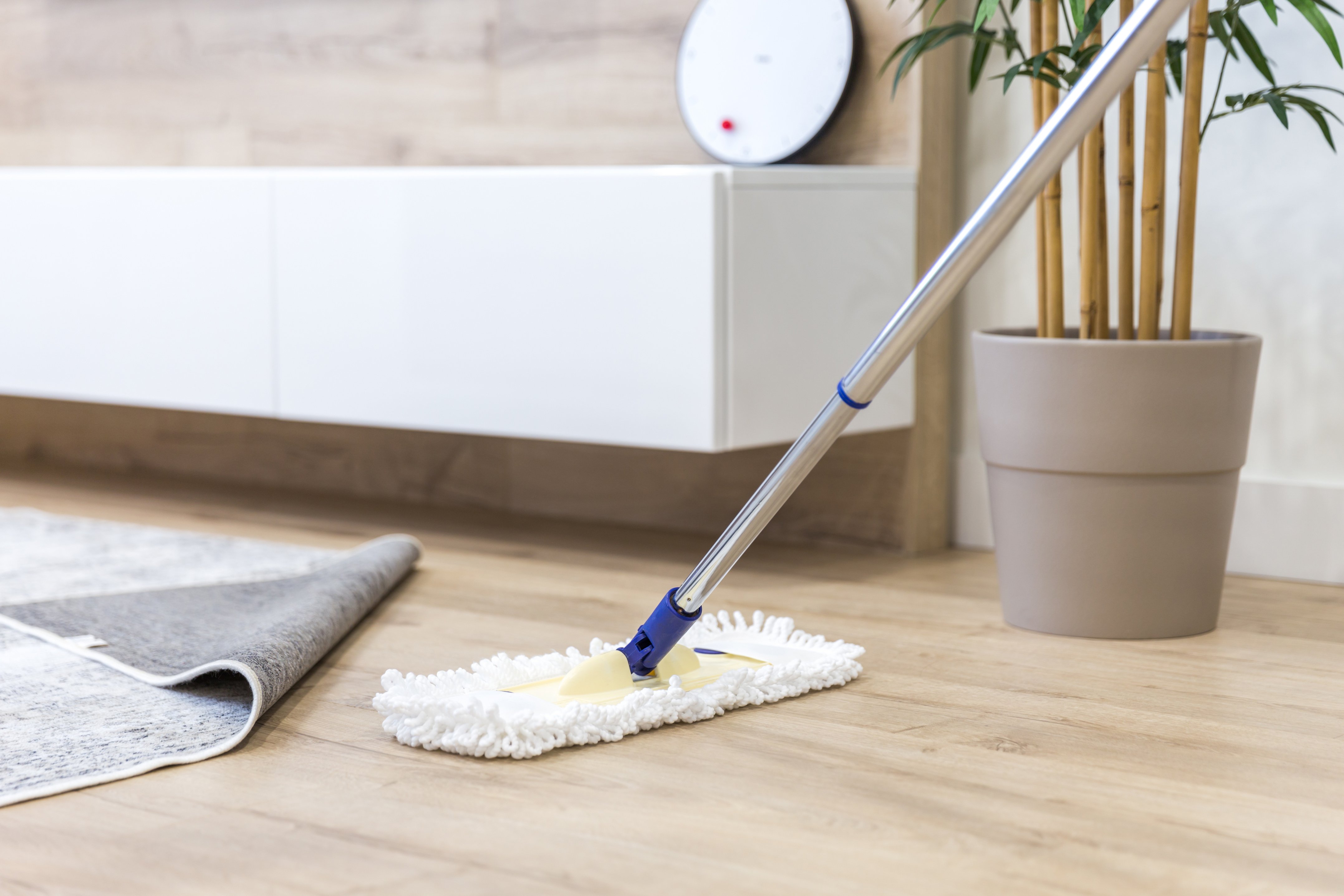 Wooden floor with white mop, cleaning service concept